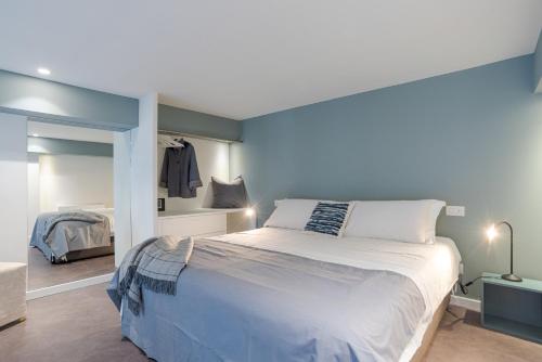 a bedroom with a large bed with a blue wall at Suite Tigli - by MyHomeInComo in Como