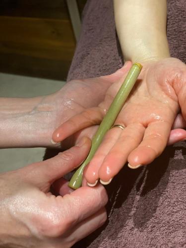 two hands holding two green bamboo sticks at Gran Paradiso Hotel Spa in San Giovanni Rotondo
