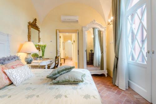 ein Schlafzimmer mit einem Bett mit Kissen darauf in der Unterkunft Casa Vera, exquisite 2 bedrooms 2 baths apartment with garden, A/C, close to Parking in Lucca