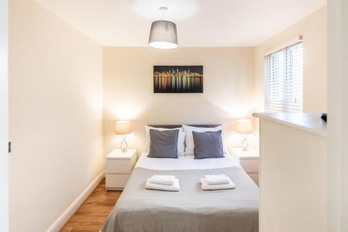 1 dormitorio con 1 cama con 2 toallas en One Bedroom Flat in Bush Hill Park, en Enfield