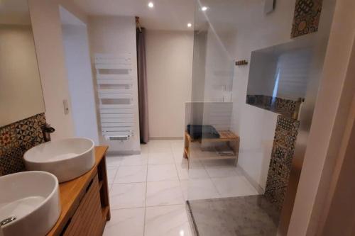 a bathroom with two sinks and a glass shower at Chez Simon et Loreline Yerres proche Paris Orly Disney in Yerres