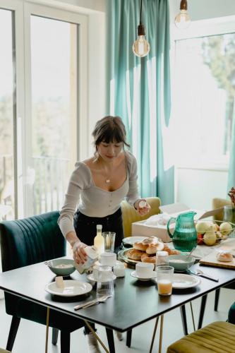 a woman standing at a table preparing food at Bett & Berg Bad Ischl, Self Check-In in Bad Ischl