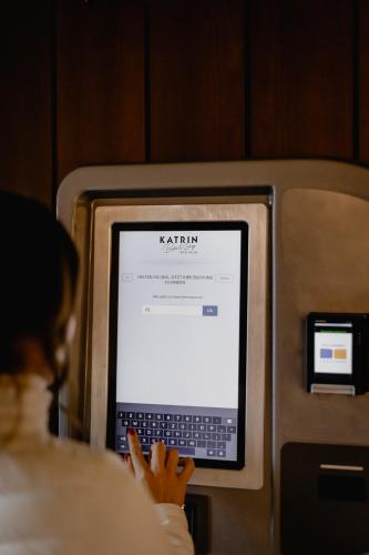 a woman is looking at a laptop computer at Bett & Berg Bad Ischl, Self Check-In in Bad Ischl