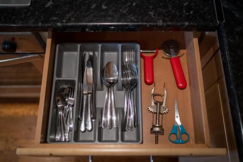 a drawer filled with silver utensils on a counter at One Bedroom Flat in Bush Hill Park in Enfield