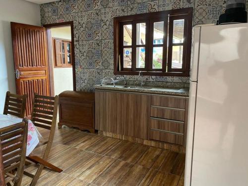 a kitchen with a refrigerator and a table and a window at Pousada da Villa in Sao Jorge