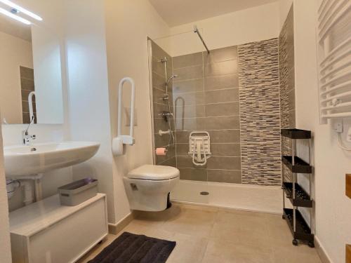 a bathroom with a shower and a toilet and a sink at Vacancéole - Résidence La Dune in Sérignan