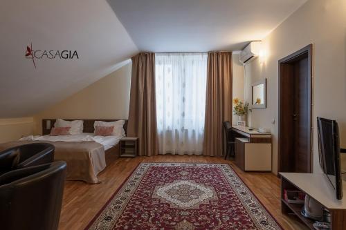 a hotel room with a bed and a television at Pension Casa Gia in Cluj-Napoca