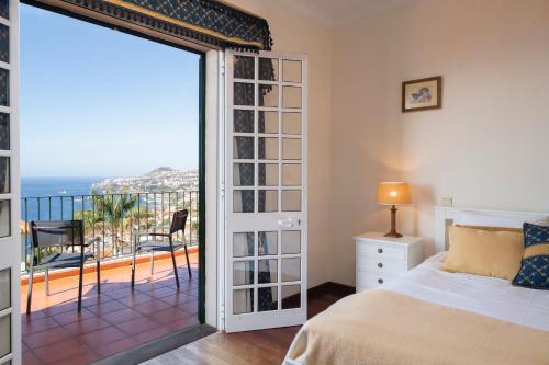 ein Schlafzimmer mit Bett und Blick auf das Meer in der Unterkunft OurMadeira - Villa Vista Sol, grand traditional in São Gonçalo