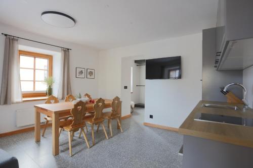 a kitchen and dining room with a table and chairs at Schneiderhaus in Mauterndorf