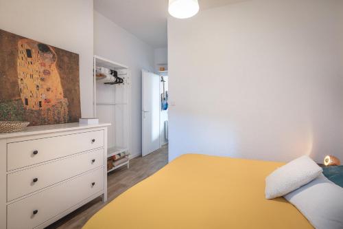 1 dormitorio con cama amarilla y vestidor en Superbe F1 avec terrasse et parking privé, en Évian-les-Bains