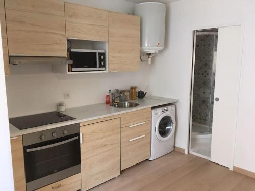 a kitchen with a sink and a washing machine at Chez Simon et Loreline Yerres proche Paris Orly Disney in Yerres