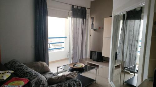 a living room with a couch and a tv at Cosy Studio on rooftop Playa Paraiso in Playa Paraiso