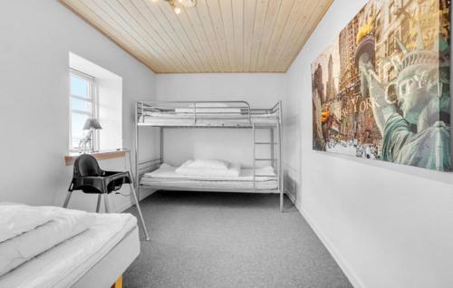 a bedroom with a bunk bed and a chair at Wonderful farmhouse in Vorbasse