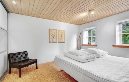 a white bedroom with a bed and a chair at Wonderful farmhouse in Vorbasse