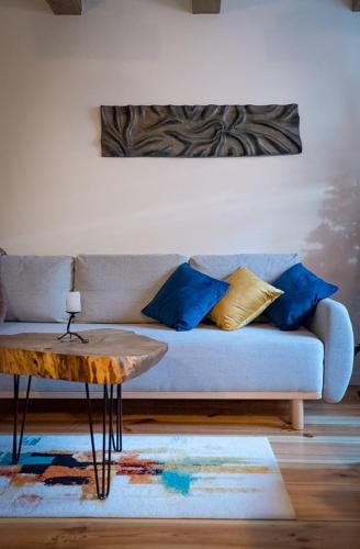a living room with a couch with blue pillows and a table at Konwaliowe Zacisze - chillout w leśnej aurze in Wilga