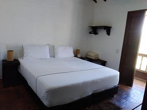 a bedroom with a large white bed in a room at Casona CHARA in Barichara