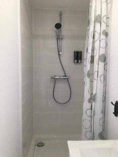 une salle de bain avec une douche avec un rideau de douche dans l'établissement Le Sirocco centre la Brèche wifi linge de pressing, à Niort