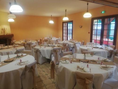 une pièce pleine de tables avec des nappes blanches dans l'établissement Au Soleil de Picardie, à Presles-et-Boves