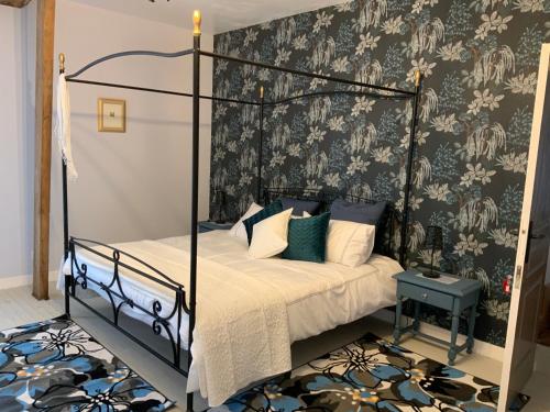 a bedroom with a bed with a black metal frame at Welcoming and peaceful bed and breakfast in Fougerolles-du-Plessis