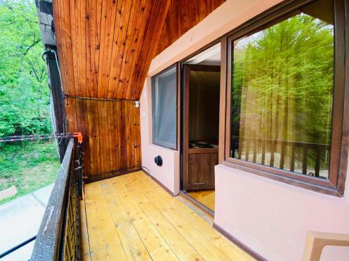 a house with a large window and a wooden floor at Likani house in Borjomi