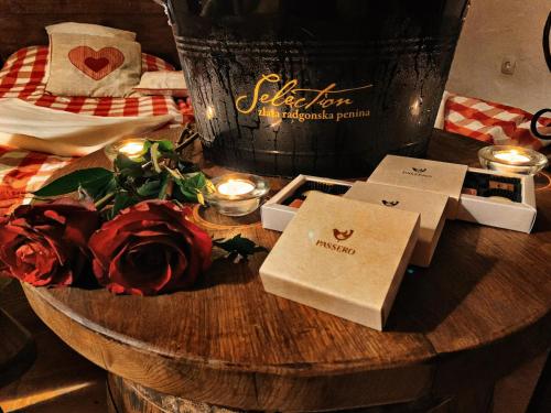a table with candles and roses and two boxes at Wellness Holiday House Lagev in Moravske Toplice