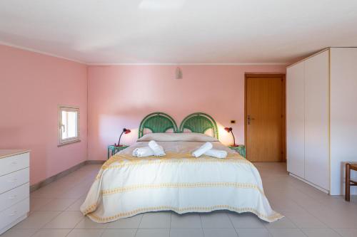 um quarto com uma cama grande e paredes cor-de-rosa em Villa erica appartamento Loredana em Villa San Pietro