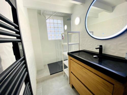 une salle de bain avec un lavabo noir et un miroir dans l'établissement Magnifique duplex vue mer inoubliable Sanary Sur Mer, à Sanary-sur-Mer