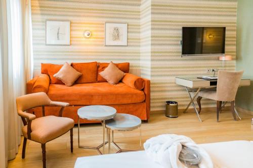 a living room with an orange couch and a table at Hotel Opera in Madrid