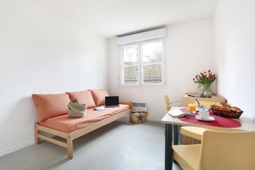 ein Wohnzimmer mit einem Sofa und einem Tisch in der Unterkunft Neoresid - Résidence Saint Germain in Amiens