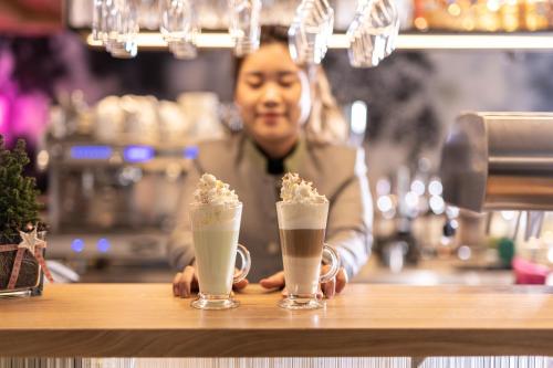 a man sitting at a bar with two milkshakes at Hotel Pirchnerhof in Reith im Alpbachtal