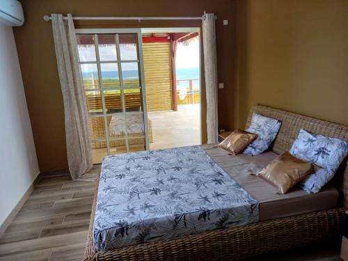 a bedroom with a bed with a view of the ocean at Villa de 3 chambres avec vue sur la mer piscine privee et jacuzzi a Le Marin in Le Marin