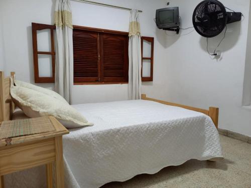 ein Schlafzimmer mit einem weißen Bett und einem Fenster in der Unterkunft LA SERRANITA - Frente al Rio in Río Ceballos