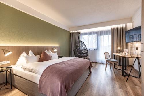 a hotel room with a bed and a desk and a chair at Hotel Pirchnerhof in Reith im Alpbachtal