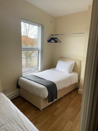 a bedroom with two beds and a window at Mersey view Hotel & Pub in Hale