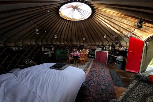 Yurt luxury + Bathhouse في Callington: غرفة مع سرير وطاولة في يورت