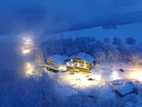 an aerial view of a house in the snow at night at Hôtel Restaurant Wolf in Markstein 