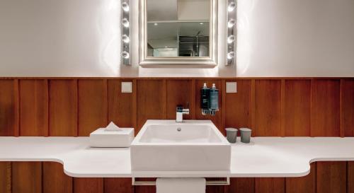 a white sink sitting under a mirror in a bathroom at Ruby Sofie Hotel Vienna in Vienna