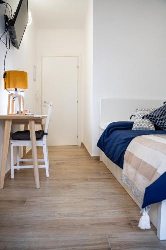 a bedroom with a bed and a table and a desk at B&B Alighieri 97 in Bari