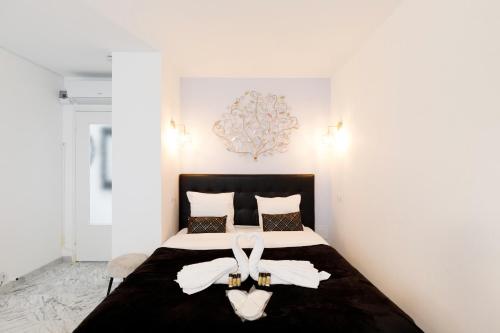 Un dormitorio con una cama con dos zapatos blancos. en Le Minerve YourHostHelper, en Cannes