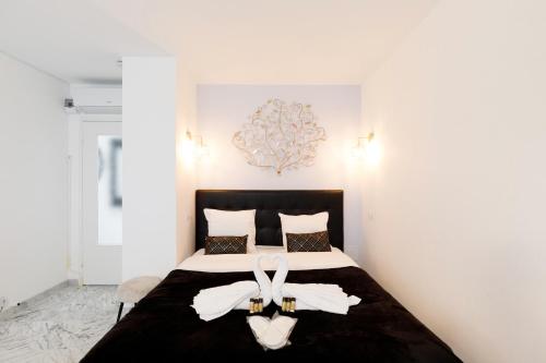 - une chambre dotée d'un lit avec deux chaussures blanches dans l'établissement Le Minerve YourHostHelper, à Cannes