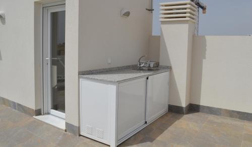 a white kitchen with a sink in a room at Palmeras Gold - Moderne villa (6p) met solarium/privézwembad in San Pedro del Pinatar