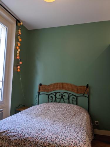 a bedroom with a bed with a green wall at Private acces to the all flat. Charming Parisian. in Paris