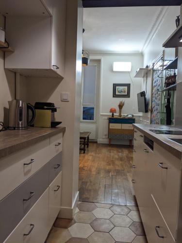 une cuisine avec des armoires blanches et un comptoir dans l'établissement Private acces to the all flat. Charming Parisian., à Paris