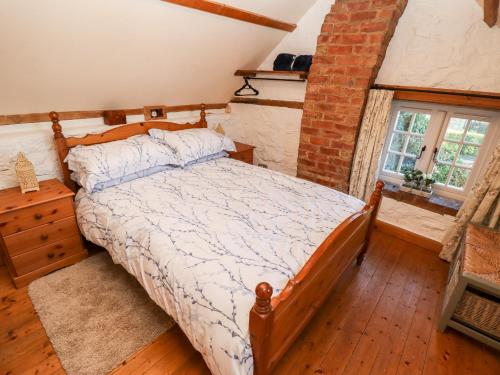 a bedroom with a bed and a brick wall at Old Blacksmiths Cottage in Market Rasen