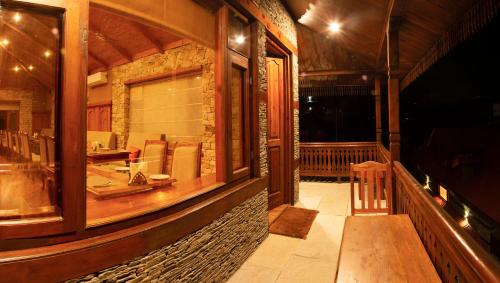 un porche de una casa con mesa y sillas en Shivadya - A Boutique Hotel en Manāli