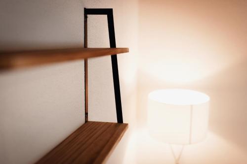 a wooden shelf with a light on a wall at Unterkunft KemptenCityHost in Kempten