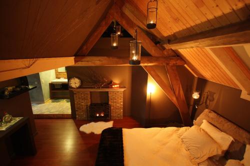 a room with a bed and a fireplace in a attic at B&B Oase in Londerzeel