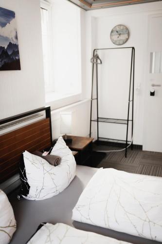 a bedroom with two beds and a clock on the wall at Unterkunft KemptenCityHost in Kempten