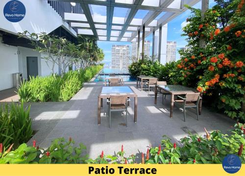 a patio terrace with tables and chairs and flowers at Revo Home at Pavilion Bukit Jalil in Kuala Lumpur