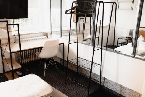 ケンプテンにあるUnterkunft KemptenCityHostのデスクと白い椅子が備わる客室です。